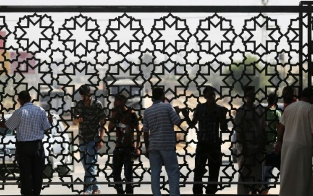 Des voyageurs palestiniens attendent avant de traverser la frontière de Rafah avec l'Egypte dans le sud de la bande de Gaza le 25 août, 2014 (Crédit : AFP Photo / Saïd Khatib)