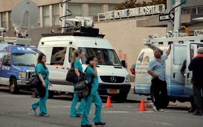 Des camions de télévision en dehors de l'hôpital Mount Sinai Août 4, 2014 New York, après que les autorités ont annoncé qu' n patient qui s'est récemment rendu en Afrique de l'Ouest est actuellement testé pour le virus Ebola. (Crédit : AFP PHOTO / Stan HONDA)