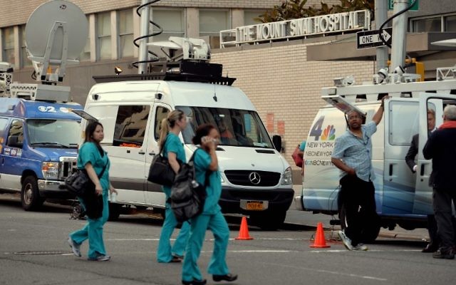 Des camions de télévision en dehors de l'hôpital Mount Sinai Août 4, 2014 New York, après que les autorités ont annoncé qu' n patient qui s'est récemment rendu en Afrique de l'Ouest est actuellement testé pour le virus Ebola. (Crédit : AFP PHOTO / Stan HONDA) Des camions de télévision en dehors de l'hôpital Mount Sinai Août 4, 2014 New York, après que les autorités ont annoncé qu' n patient qui s'est récemment rendu en Afrique de l'Ouest est actuellement testé pour le virus Ebola. (Crédit : AFP PHOTO / Stan HONDA)