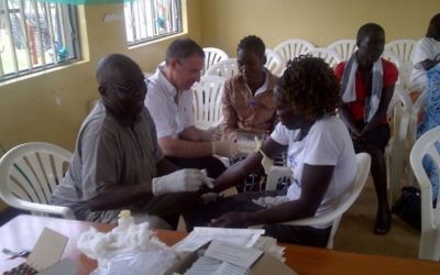 Dr Leslie Lobel (deuxième à gauche) supervise la prise de sang d'un survivant d'Ebola en Ouganda pour son étude. (Crédit : autorisation de Leslie Lobel)