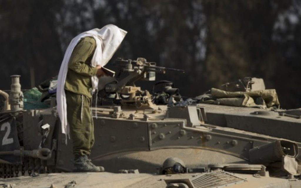 Un soldat israélien prie depuis la bande de Gaza lors de l'Opération Bordure protectrice (Crédit : Yonatan Sindel/Flash 90)
