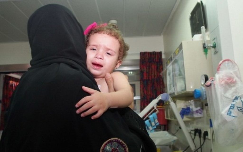 Hala Arada, âgée de deux ans, avec sa grand-mère Haniyeh Shaer à l'hôpital Wolfson à Holon, le 12 août 2014. Hala a une maladie cardiaque congénitale et est traitée en Israël. Deux membres de sa famille ont récemment été tués dans un raid aérien israélien à Gaza. (Crédit : Sheila Shalhevet / Save a Child's heart) Hala Arada, âgée de deux ans, avec sa grand-mère Haniyeh Shaer à l'hôpital Wolfson à Holon, le 12 août 2014. Hala a une maladie cardiaque congénitale et est traitée en Israël. Deux membres de sa famille ont récemment été tués dans un raid aérien israélien à Gaza. (Crédit : Sheila Shalhevet / Save a Child's heart)