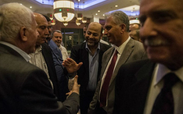 Le chef-adjoint du Hamas, Moussa Abu Marzouk (au centre) serre la main au chef de la délégation palestinienne, Azzam al-Ahmad (à gauche), après une réunion avec des hauts-responsables égyptiens, le 11 août 2014. (Crédit : AFP/Khaled Desouki) Le chef-adjoint du Hamas, Moussa Abu Marzouk (au centre) serre la main au chef de la délégation palestinienne, Azzam al-Ahmad (à gauche), après une réunion avec des hauts-responsables égyptiens, le 11 août 2014. (Crédit : AFP/Khaled Desouki)
