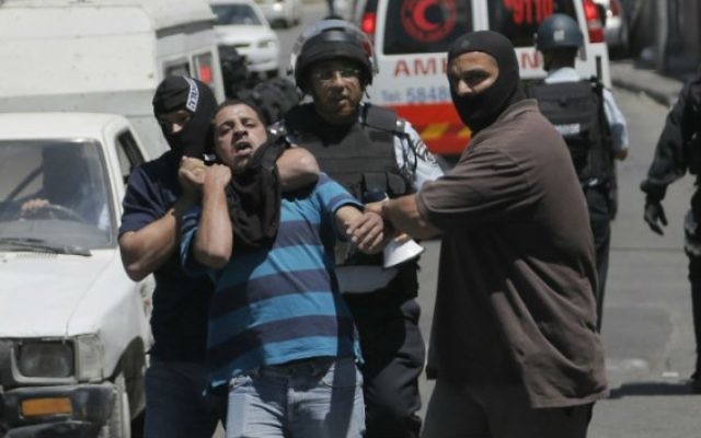 Des policiers israéliens arrêtant un palestinien suspecté d'avoir jeté des pierres dans le quartier de Wadi al-Joz, à Jérusalem. (Crédit : Sliman Khader/Flash90)