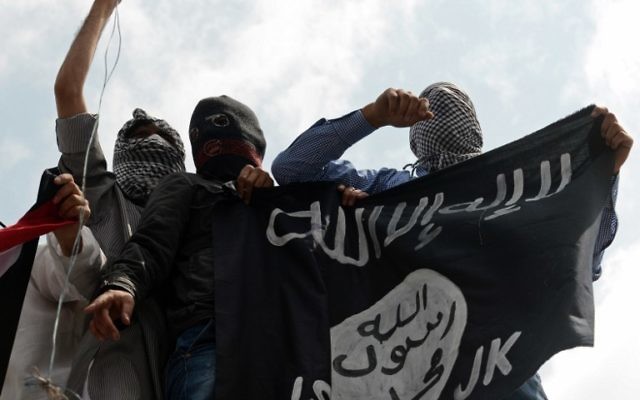Des manifestants tiennent un drapeau de l'Etat islamique lors d'une protestation contre Israël, au centre de Srinagar, à Cachemire - le 18 juillet 2014 (Crédit : AFP / Tauseef MUSTAFA)