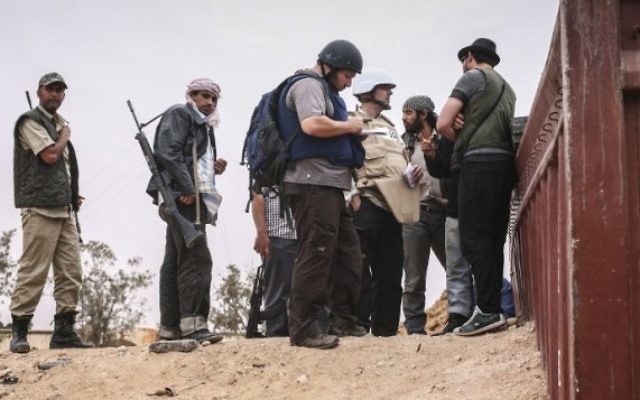 Steven Sotloff (au centre avec un casque noir) discutant avec des rebelles libyens, le 2 juin 2011.(Crédit : autorisation Etienne de Malgraive, via AFP) Steven Sotloff (au centre avec un casque noir) discutant avec des rebelles libyens, le 2 juin 2011.(Crédit : autorisation Etienne de Malgraive, via AFP)