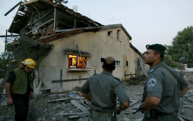 Des forces de sécurité israéliennes inspectent les dommages à une maison après une attaque à la roquette Katioucha du Hezbollah dans le nord d'Israël à Nahariya, le 15 juillet, 2006 (Crédit photo: Pierre Terdjman / Flash90)