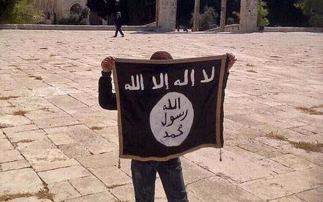 Un jeune adolescent tient un drapeau de l'Etat islamique sur le mont du Temple (Crédit : Facebook)