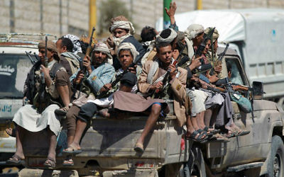 Des rebelles de l'armée yéménite chiite houthie anti-gouvernementaux sont assis à l'arrière d'un pick-up alors qu'ils roulent près de l'enceinte de la télévision d'Etat dans la capitale de Sanaa, le 21 septembre 2014 (Crédit : AFP / Mohammed Huwais)