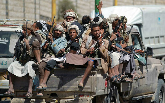 Des rebelles de l'armée yéménite chiite houthie anti-gouvernementaux sont assis à l'arrière d'un pick-up alors qu'ils roulent près de l'enceinte de la télévision d'Etat dans la capitale de Sanaa, le 21 septembre 2014 (Crédit : AFP / Mohammed Huwais)