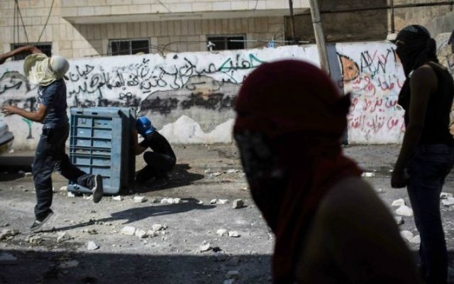 Des Palestiniens masqués s'affrontent avec des policiers israéliens à Abu Tor - 30 octobre 2014 (Crédit : Hadas Parush/Flash90)
