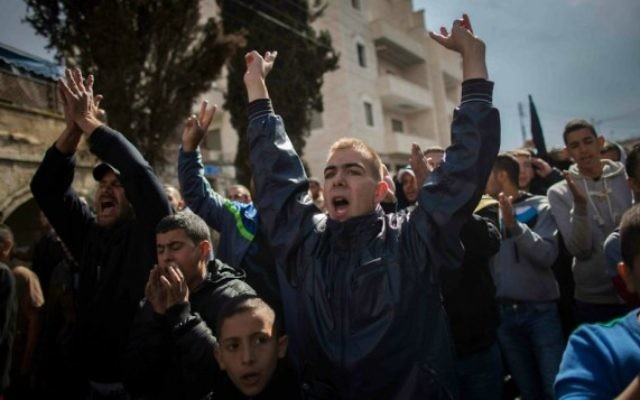 Des jeunes palestiniens prient devant un cordon de policiers israéliens dans le quartier de Wadi al-Joz à Jérusalem-Est 31 octobre 2014. (Crédit : Yonatan Sindel / Flash90)