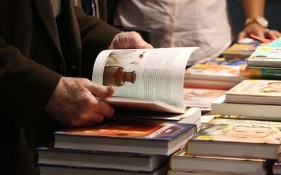 Un homme parcourt un livre à la Foire du livre de Francfort (Crédit : AFP/Daniel Roland)