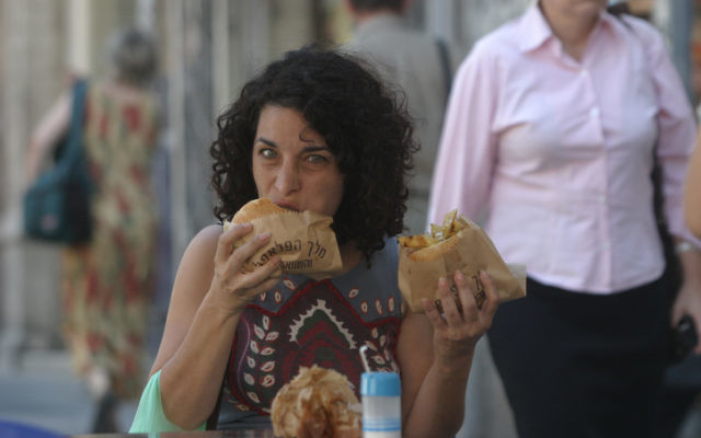 Une femme mange un falafel qui a la réputation internationale d'être rempli de fibres végétales. (Crédit : Orel Cohen / Flash90) Une femme mange un falafel qui a la réputation internationale d'être rempli de fibres végétales. (Crédit : Orel Cohen / Flash90)