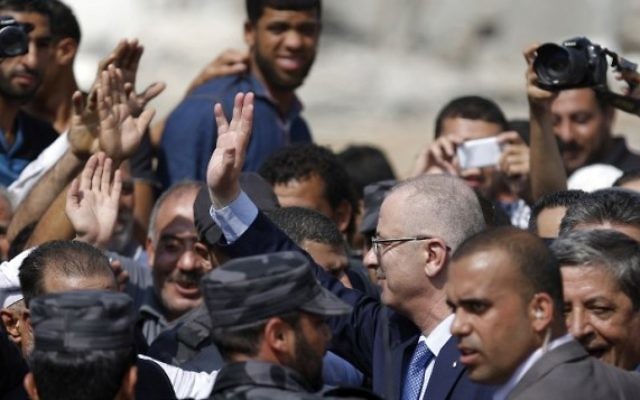 Le Premier ministre de l'Autorité palestinienne Rami Hamdallah (C) salue les gens lors d'une visite dans le quartier Chajaya la ville de Gaza, le 9 O
octobre, 2014. (Crédit : Saïd Khatib / AFP) Le Premier ministre de l'Autorité palestinienne Rami Hamdallah (C) salue les gens lors d'une visite dans le quartier Chajaya la ville de Gaza, le 9 O
octobre, 2014. (Crédit : Saïd Khatib / AFP)