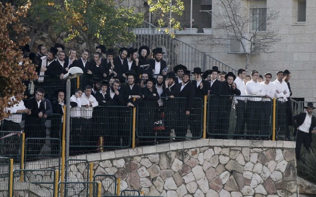 Des Israéliens regardent le lieu de l'attentat terroriste contre la synagogue d'Hart Nof - 18 novembre 2014 (Crédit : Jack Guez/AFP) Des Israéliens regardent le lieu de l'attentat terroriste contre la synagogue d'Hart Nof - 18 novembre 2014 (Crédit : Jack Guez/AFP)