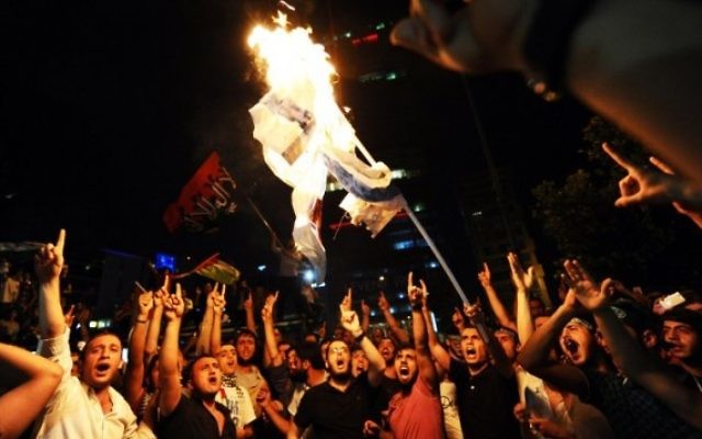 Des manifestants turcs mettent le feu à un drapeau israélien lors d'une manifestation contre l'opération israélienne dans la bande de Gaza, le 19 juillet 2014, devant le consulat israélien à Istanbul. (Crédit : Ozan Kose / AFP) Des manifestants turcs mettent le feu à un drapeau israélien lors d'une manifestation contre l'opération israélienne dans la bande de Gaza, le 19 juillet 2014, devant le consulat israélien à Istanbul. (Crédit : Ozan Kose / AFP)