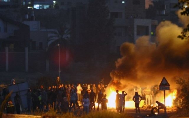Jeunes Palestiniens jetant des pierres tsur des policiers israéliens devant le village de Kafr Kanna au nord d'Israël, le 9 novembre 2014 (Crédit : Flash90) Jeunes Palestiniens jetant des pierres tsur des policiers israéliens devant le village de Kafr Kanna au nord d'Israël, le 9 novembre 2014 (Crédit : Flash90)