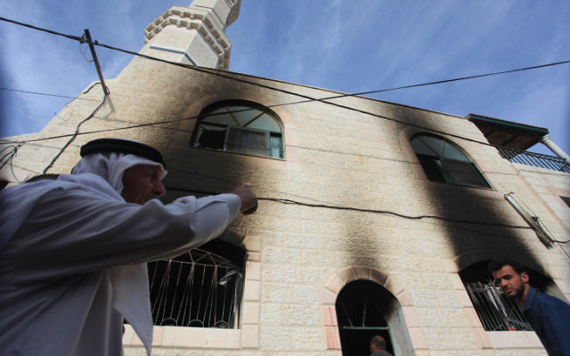 Des Palestiniens inspectent une mosquée qui a été incendiée dans le village d'al-Mughayir, en Cisjordanie près de l'implantation juive de Shilo, le 12 novembre, 2014. (Crédit : STR / Flash90)