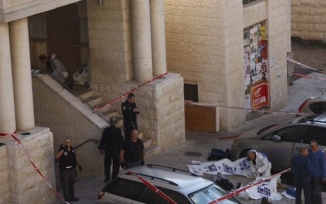 La police israélienne à l'extérieur de la synagogue Kehilat Yaakov à Jérusalem après une attaque terroriste le 18 novembre 2014. Les corps des deux terroristes sont recouverts de plastique (Crédit : Yonatan Sindler / FLASH90) La police israélienne à l'extérieur de la synagogue Kehilat Yaakov à Jérusalem après une attaque terroriste le 18 novembre 2014. Les corps des deux terroristes sont recouverts de plastique (Crédit : Yonatan Sindler / FLASH90)