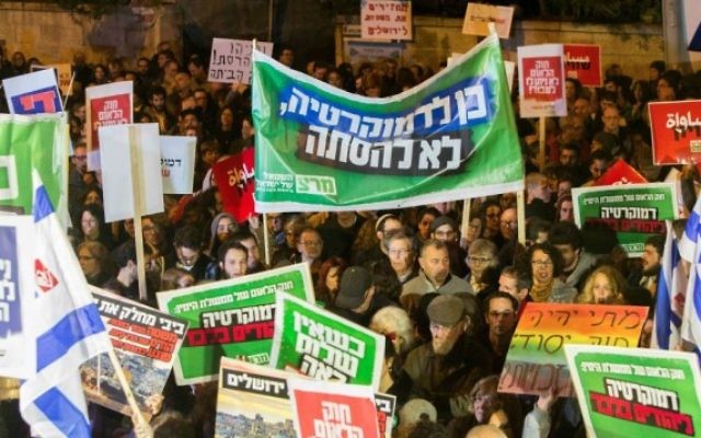 Des militants de gauche brandissent des pancartes et des drapeaux alors qu'ils protestent contre le projet de loi "Etat juif" près de la résidence du Premier ministre à Jérusalem le 29 novembre, 2014. (Crédit :  Yonatan Sindel / Flash90)