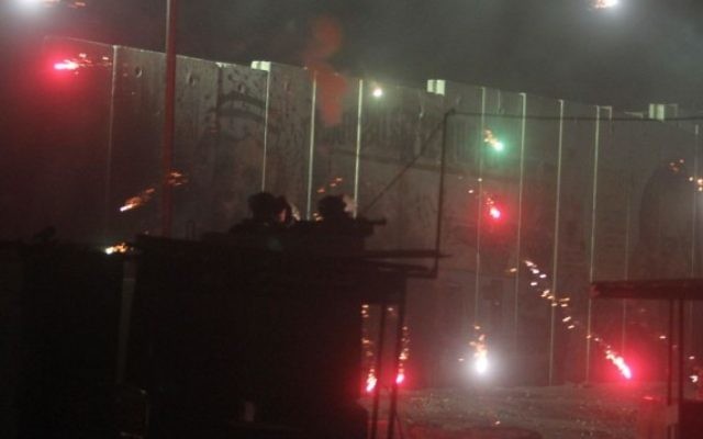 La police des frontières israélienne et un soldat affrontent des Palestiniens au poste de contrôle de Qalandiya, le 24 Juillet, 2014. (Crédit : Issam Rimawi / FLASH90)