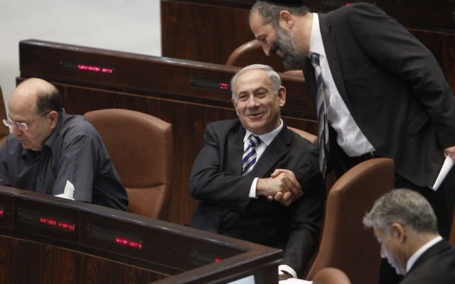 Le Premier ministre Benjamin Netanyahu et le président du Shas Aryeh Deri pendant une session à la Knesset (Crédit : Miriam Alster/Flash90) Le Premier ministre Benjamin Netanyahu et le président du Shas Aryeh Deri pendant une session à la Knesset (Crédit : Miriam Alster/Flash90)