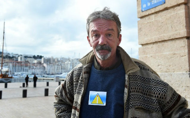 Arnaud, un homme sans-abri, porte un "badge de sécurité" lors d'une manifestation en face de l'Hôtel de Ville de Marseille, sud de la France, le 3 décembre, 2014. (Crédit : AFP / Anne-Christine Poujoulat) Arnaud, un homme sans-abri, porte un "badge de sécurité" lors d'une manifestation en face de l'Hôtel de Ville de Marseille, sud de la France, le 3 décembre, 2014. (Crédit : AFP / Anne-Christine Poujoulat)