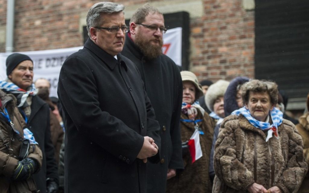 Le président polonais Bronislaw Komorowski (CL), Piotr Cywinski (CR), directeur du musée d'Auschwitz-Birkenau et des survivants rendent hommage aux victimes des nazis à l'endroit de l'exécution "du mur de la mort" dans l'ancien camp de concentration d'Auschwitz à Oswiecim, Pologne, lors du 70e anniversaire de la libération du camp de la mort nazi le 27 Janvier, 2015 (Crédit : AFP PHOTO / ODD ANDERSEN)
