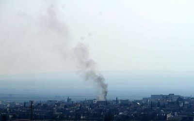 Une photo de la ville de Kobane prise le 26 janvier 2015 de la ville de Sanliufra d'où on peut voir de la fumée s'élever après les affrontements entre l'EI et les kurdes (Crédit : AFP)