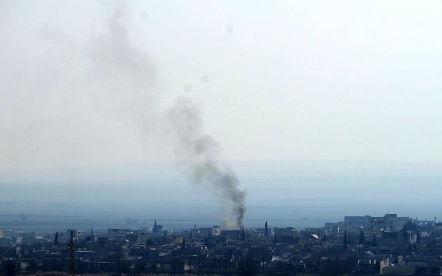 Une photo de la ville de Kobane prise le 26 janvier 2015 de la ville de Sanliufra d'où on peut voir de la fumée s'élever après les affrontements entre l'EI et les kurdes (Crédit : AFP)