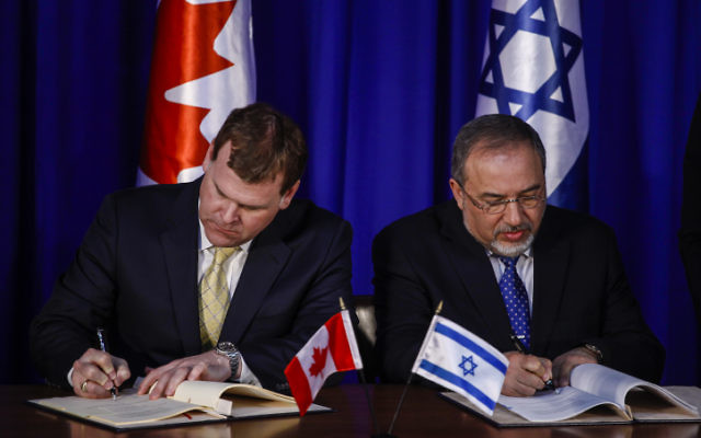 Le ministre israélien des Affaires étrangères, Avigdor Liberman, et le ministre canadien des Affaires étrangères, John Baird, signent un document - mardi 21 Janvier, 2014. (Crédit : Flash 90.)
