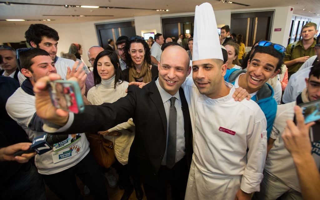 Le dirigeant de HaBayit HaYehudi, Naftali Bennett (celui qui ne porte pas la toque de cuisinier) avec ses supporters après avoir voté aux primaires de sont parti le 14 janvier 2015 (Crédit : Yonatan Sindel/Flash90)