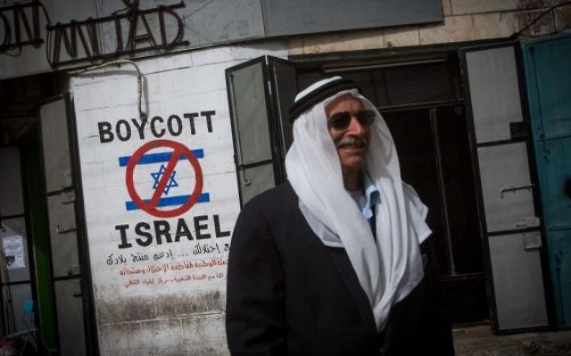 Un Palestinien passe à côté d'une affiche prônant le boycott d'Israël dans la ville de Bethléem en Cisjordanie le 11 février 2015 (Crédit : Miriam Alster/Flash90) Un Palestinien passe à côté d'une affiche prônant le boycott d'Israël dans la ville de Bethléem en Cisjordanie le 11 février 2015 (Crédit : Miriam Alster/Flash90)