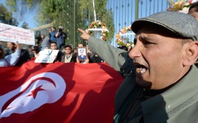 Des Tunisiens brandissant le drapeau pour protester contre l'attentat au musée Bardo - 19 mars 2015 (Crédit : AFP)