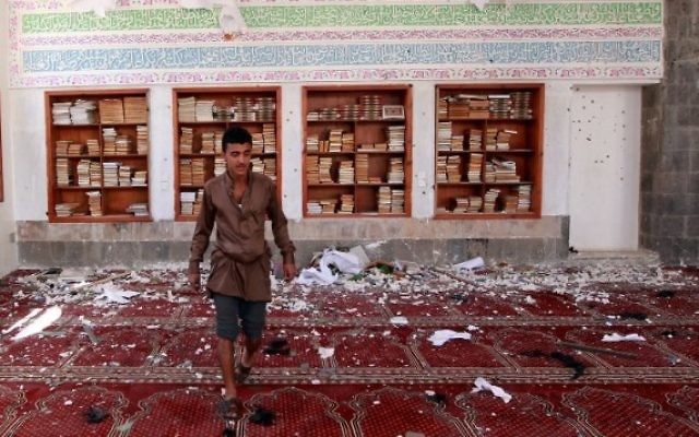 Un homme yéménite inspecte les dégâts suite à une explosion d'une bombe à la mosquée Badr dans le sud de Sanaa, le 20 mars, 2015. (Crédit : AFP / MOHAMMED HUWAIS)