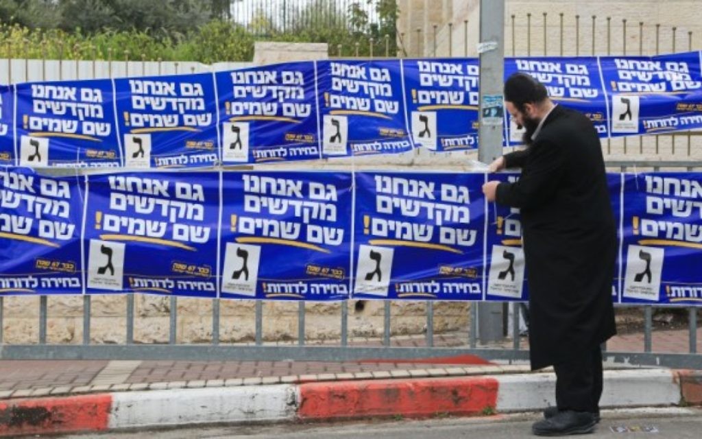 Un partisan ultra-orthodoxe de YaHadout HaTorah vu en train d'accrocher des affiches de campagne dans la ville de Beit Shemesh, le 17 mars, 2015. (Crédit : Yaakov Naumi / FLASH90) Un partisan ultra-orthodoxe de YaHadout HaTorah vu en train d'accrocher des affiches de campagne dans la ville de Beit Shemesh, le 17 mars, 2015. (Crédit : Yaakov Naumi / FLASH90)