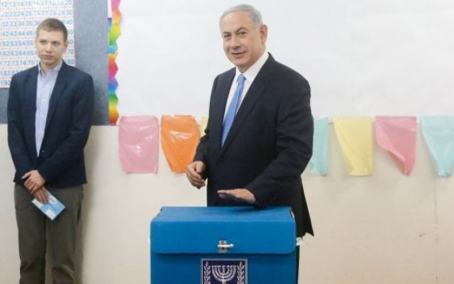 Le Premier ministre Benjamin Netanyahu et un de ses fils, à un bureau de vote de Jérusalem, le 17 mars 2015 (Crédit photo: Marc Israël Sellem / POOL / FLASH90)