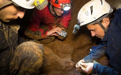 Un membre du club israélien de spéléologie et des responsables de l'Autorité israélienne des antiquités dans une grotte du Nord d'Israël, en février 2015 (photo credit: Samuel Magal/Israel Antiques Authority).