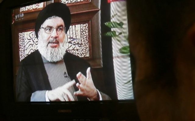 Un syrien regarde une interview de Hassan Nasrallah diffusé sur la chaîne de télévision officielle syrienne Al-Ikhbariya, à Damas, le 6 avril 2015. (Crédit : AFP / STR)