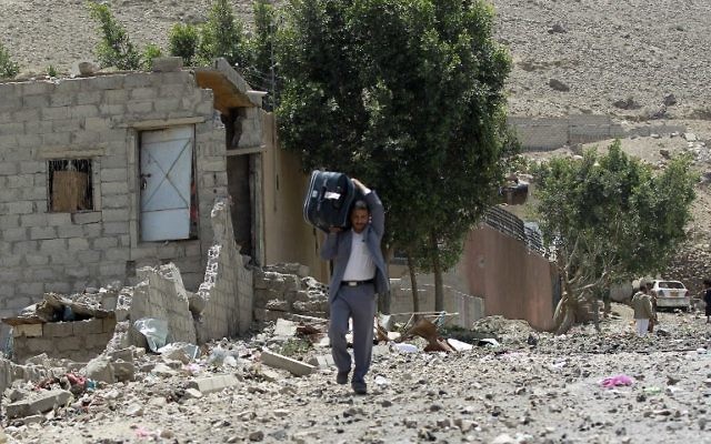 Un homme transporte ses affaires après que sa maison ait été bombardée - Yémen - 22 avril 2015 (Crédit : AFP) Un homme transporte ses affaires après que sa maison ait été bombardée - Yémen - 22 avril 2015 (Crédit : AFP)