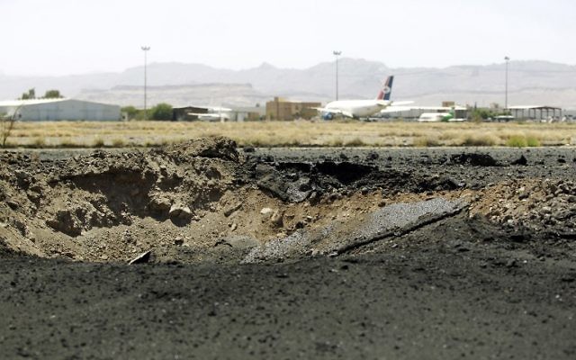 Cratère laissé par une frappe aérienne sur le tarmac de l'aéroport international de Sanaa, capitale du Yémen, le 29 avril 2015. (Crédit : Mohammed Huwais/AFP)