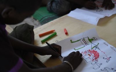 Un jeune réfugié nigérian dessine une scène d'attaque le 6 avril 2015 au cours d'une thérapie gérée par l'UNICEF dans le camp de réfugiés près de Baga Sola  (Crédit : AFP PHOTO / PHILIPPE DESMAZES)