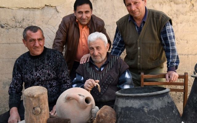Une photo prise le 24 février, 2015 montre Mnatsakan Muradyan (C), le petit-fils de Martiros Muradyan, posant avec ses parents dans le village de Poker Vidéo, au sud d'Erevan, près de la montagne Ararat en Arménie. Les descendants de Martiros Muradyan chérissent comme des reliques religieuses les quelques objets qu'il a pu prendre avec lui quand il a fuit les massacres il y a cent ans (Crédit : AFP PHOTO / KAREN MINASYAN)