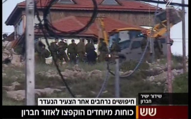 Les soldats de Tsahal à l'extérieur du village cisjordanien de Beit Anun, près d'Hébron, à la recherche d'un Israélien qui a disparu le 2 avril 2015 (Crédit : Capture d'écran Deuxième chaîne)