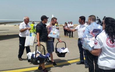 Le ministre de l'intérieur Gilad Erdan (2nd à droite) et le directeur de Magen David Adom, Eli Bean (3ème à droite) accueillent les parents qui arrivent avec leurs nouveau-nés en Israël, le 27 avril 2015. (Crédit : MDA)