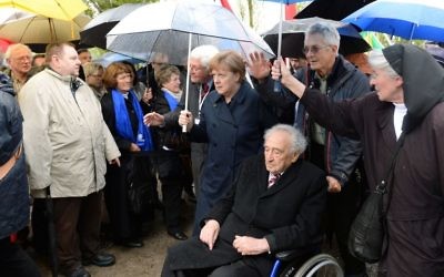 La chancelière allemande Angela Merkel (C) marche avec un survivant de l'Holocauste Max Mannheimer (3ème D) à l'ancien camp de concentration nazi de Dachau, au sud-ouest de l'Allemagne, lors d'une cérémonie marquant les 70 ans de sa libération par les forces américaine, le 29 avril 1945 -  le 3 mai 2015 (Crédit : AFP PHOTO / CHRISTOF STACHE)