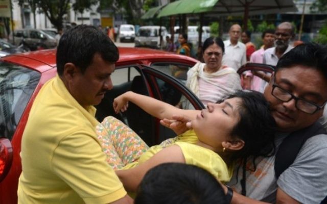 Le personnel d'un hôpital et des passants assistent une résidente qui s'est évanouie pendant le tremblement de terre, à Siliguri Siliguri, le 12 mai 2015. (Crédit : AFP / Diptendu DUTTA)