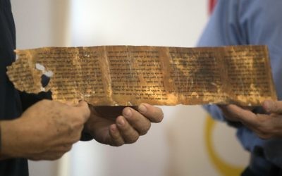 (FILES) Une photo prise le 18 décembre, 2012 montre le Directeur général de l'Autorité des Antiquités d'Israël Shuka Dorfmann et le professeur Yossi Matias, directeur général de Google Israël, montrant une réplique d'un segment du manuscrit des Dix Commandements extraits du livre biblique du Deutéronome lors d'une conférence de presse au Musée Rockefeller à Jérusalem. (Crédit : AFP PHOTO / MENAHEM KAHANA)