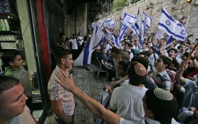 De jeunes israéliens devant un magasin arabe de la Vieille Ville au cours de la marche des drapeaux du Jour de Jérusalem, le 21 mai 2009. (Crédit : Abir Sultan / Flash90)